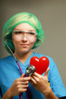 A doctor with stethoscope examining red heart