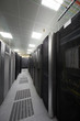 Telecommunications equipment in racks and cables in server room.