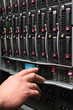 Foto: Man controls the server rack with a hard drives. Man controls the server rack with a hard drives.