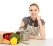 Woman in apron sitting on the desk with grocery bag