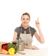 Woman in apron sitting on the desk with grocery bag