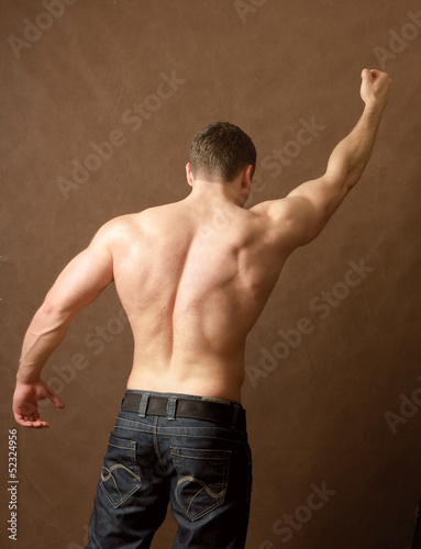 Photo: Muscular man, isolated on brown background Muscular man, isolated on brown background