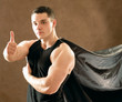 Photo: A man showing thumb up sign, isolated on brown background A man showing thumb up sign, isolated on brown background