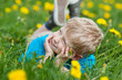 kleiner junge liegt im grünen gras