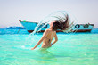 Foto: Young brunette jumping out of turquoise water of Red Sea, Egypt Young brunette jumping out of turquoise water of Red Sea, Egypt