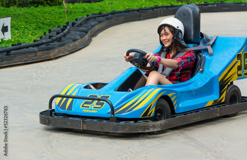 Photo: Cute Thai girl is driving Go-kart in an amusement park Cute Thai girl is driving Go-kart in an amusement park