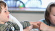 Mother and little boy using nebulizer to inhale medicine, DOF