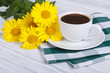 Aromatic coffee and a bouquet of yellow daisies
