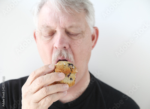Photo: older man with blueberry muffin older man with blueberry muffin