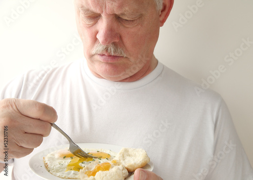 Photo: man having fried eggs and biscuits man having fried eggs and biscuits