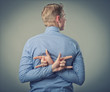 businessman showing two fingers behind his back