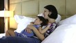 Mother and daughter speaking on the bed