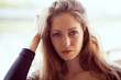 Beautiful young woman straightens long dark hair