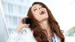 Beautiful business woman talking on cell phone while looking at