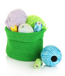 Colorful yarn for knitting in green basket isolated on white