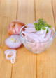 Onion cut with rings in bowl on wooden table close-up