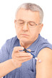 Middle aged man injecting insulin in his arm