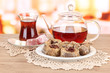 Sweet baklava on plate with tea on table in room