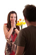Surprised young woman receiving bouquet of daffodils from her bo