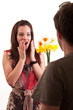 Surprised young woman receiving bouquet of daffodils from her bo