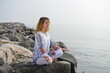 Meditation, Woman on rocky beach in yoga pose
