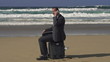 Young businessman talking on cellphone on the beach