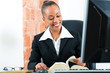 Lawyer in office with law book and computer