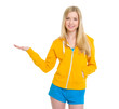 Happy teenager girl presenting something on empty palm