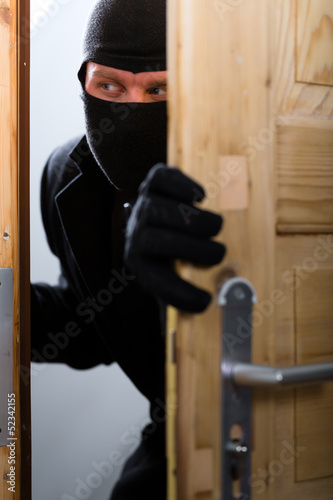 Photo: Burglary crime - burglar opening a door Burglary crime - burglar opening a door