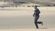 Businessman jogging on exotic beach, super slow motion, shot at 