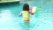 Little girl playing with a colorful ball in the pool