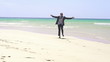 Excited businessman running on the beach, super slow motion