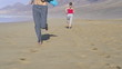 Man and woman jogging on the beach, super slow motion