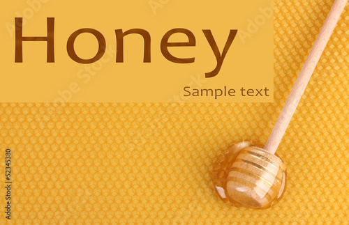 Photo: Yellow beautiful honeycomb and wooden honey dipper with honey . Yellow beautiful honeycomb and wooden honey dipper with honey .
