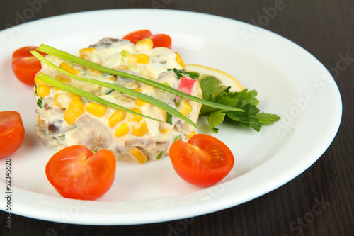 Photo: Small portion of food on big plate on wooden table Small portion of food on big plate on wooden table