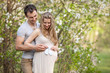 Photo: Young pregnant couple outdoors in spring Young pregnant couple outdoors in spring