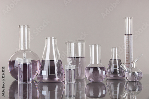 Photo: Test-tubes with light purple liquid on gray background Test-tubes with light purple liquid on gray background