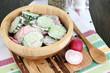 Vitamin vegetable salad in wooden bowl on wooden table close-up
