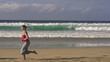 Man and woman jogging on the beach, super slow motion