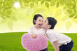 Photo: Boy kiss girl under green leaves Boy kiss girl under green leaves