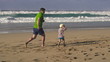 Father, son and joggers on the beach