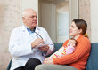 Photo: Male mature pediatrician doctor examining newborn baby Male mature pediatrician doctor examining newborn baby