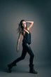 Foto: Fashion model wearing leather pants posing on grey Fashion model wearing leather pants posing on grey
