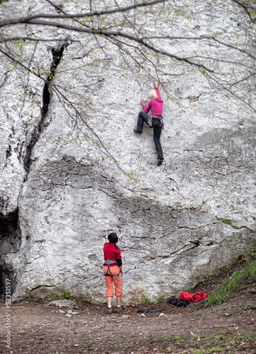Photo: Young women climbing on limestone wall Young women climbing on limestone wall