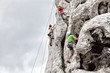 Young man and child climbing on limestone wall