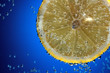 Slice of fresh lemon in water with air bubbles