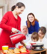Mature woman in red pours tea
