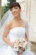 Photo: Smiling bride in white dress with bouquet of flowers Smiling bride in white dress with bouquet of flowers