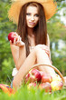 Beautiful woman in the garden with apples
