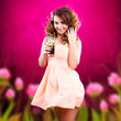 lächelnde junge Frau im Sommerkleid und mit Cocktail